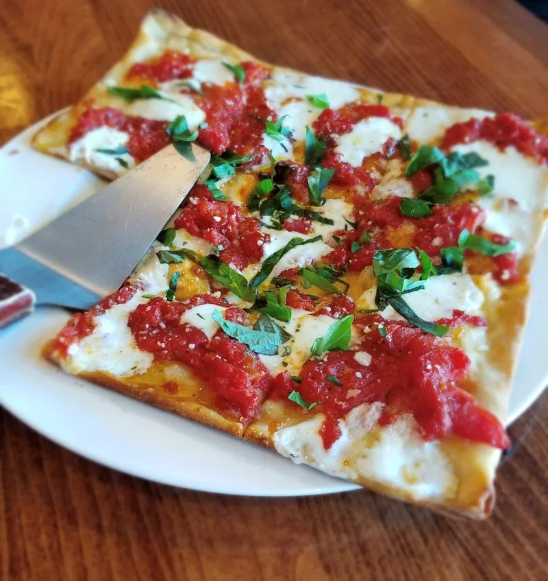 Old world tomato pie topped with fresh mozzarella and basil