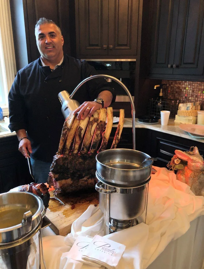 Chef carving a spit-roasted porchetta at a Piccolo Trattoria event