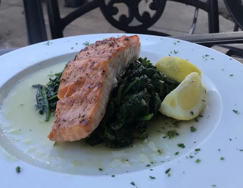 Pan seared salmon over sautéed spinach with lemon